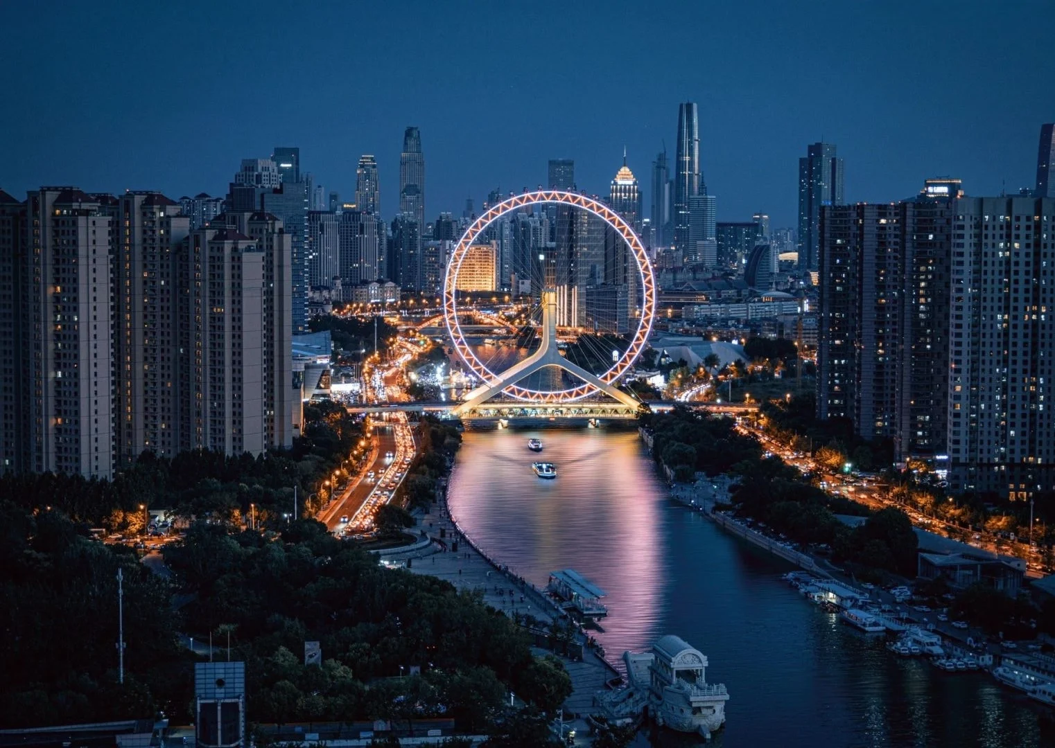 Tianjin Eye om natten Tianjin Eye pariserhjulet er smukt oplyst om natten og tilbyder en fantastisk udsigt over byens skyline, der spejler sig i vandet nedenfor.