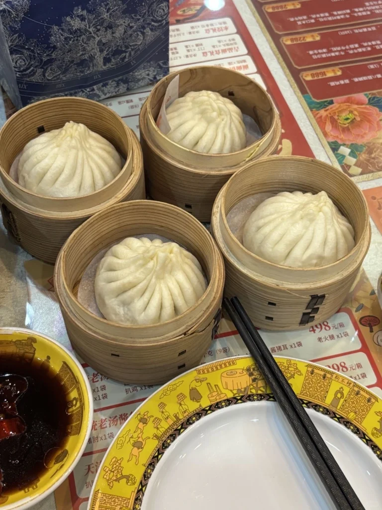 Tianjin Dog Bites Bun Restaurant Four bamboo steamers filled with freshly steamed Dog Bites buns a classic Tianjin dish