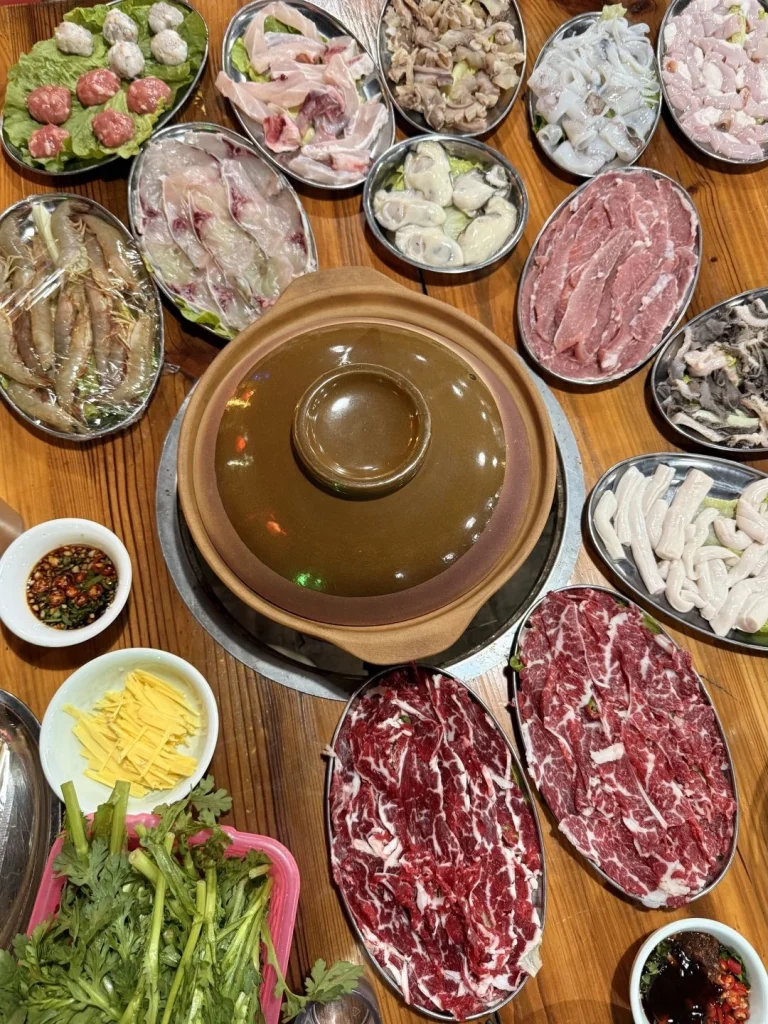 Traditional Guangdong hotpot featuring fresh seafood meats and vegetables in a steaming pot of broth