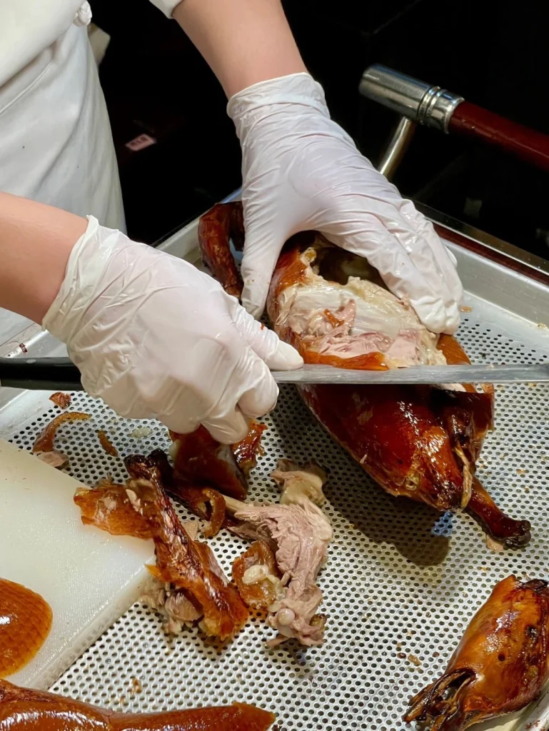 Traditional carving of Peking duck at a famous Beijing roast duck restaurant showing skillful preparation