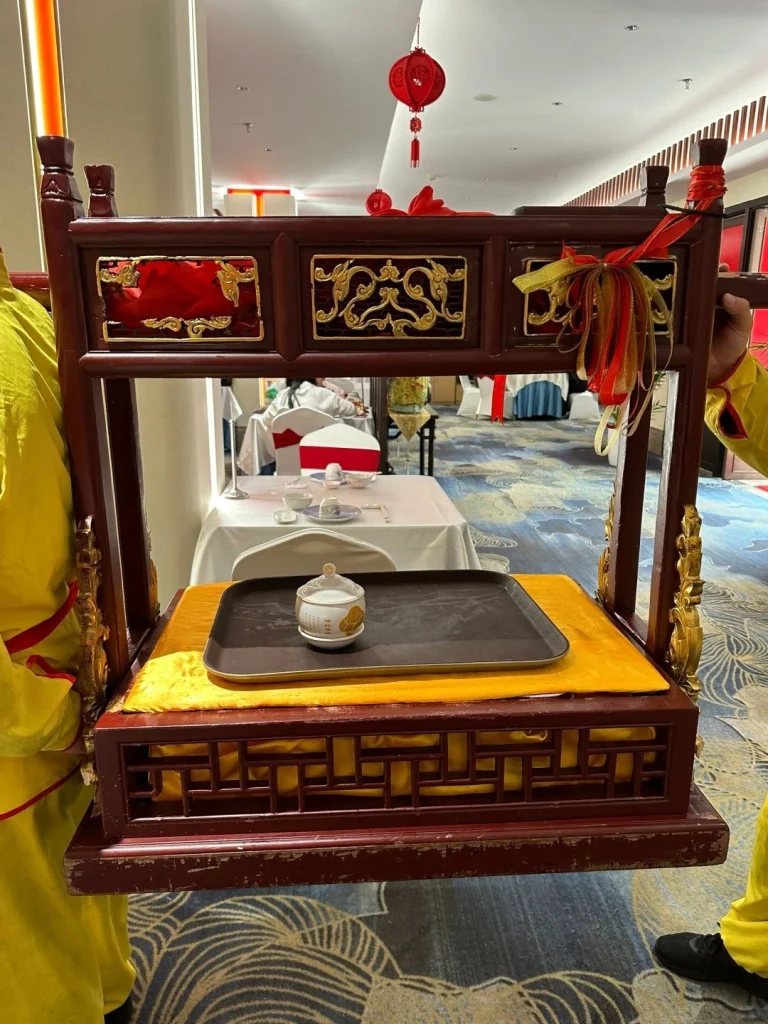 Traditional serving tray at Juchun Garden A detailed shot of a wooden serving tray decorated with red ribbons used to serve dishes at Juchun Garden Fuzhou