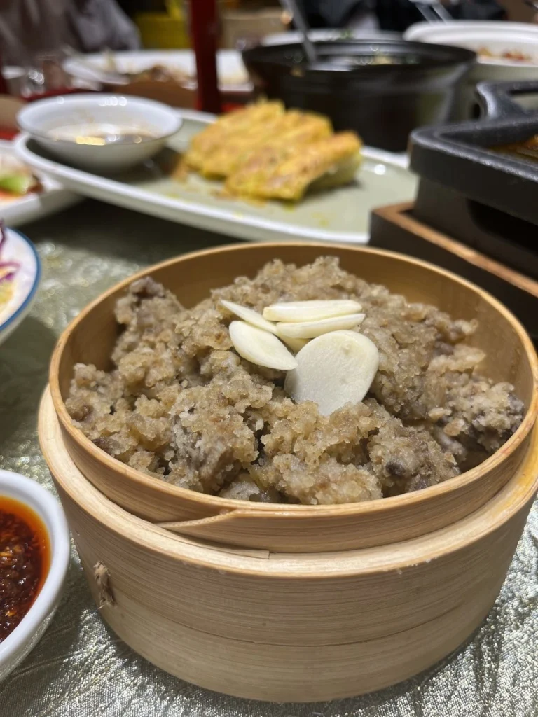 Xian Restaurant dish presentation A close up of Xian Restaurants specialty food served in a traditional bamboo container with garlic and other ingredients