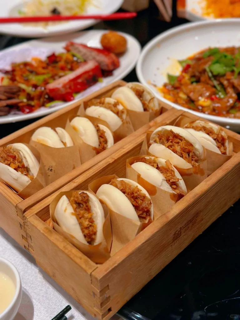 Xian Restaurant food offering Close up of a wooden container filled with Xian Restaurants famous buns served with various side dishes