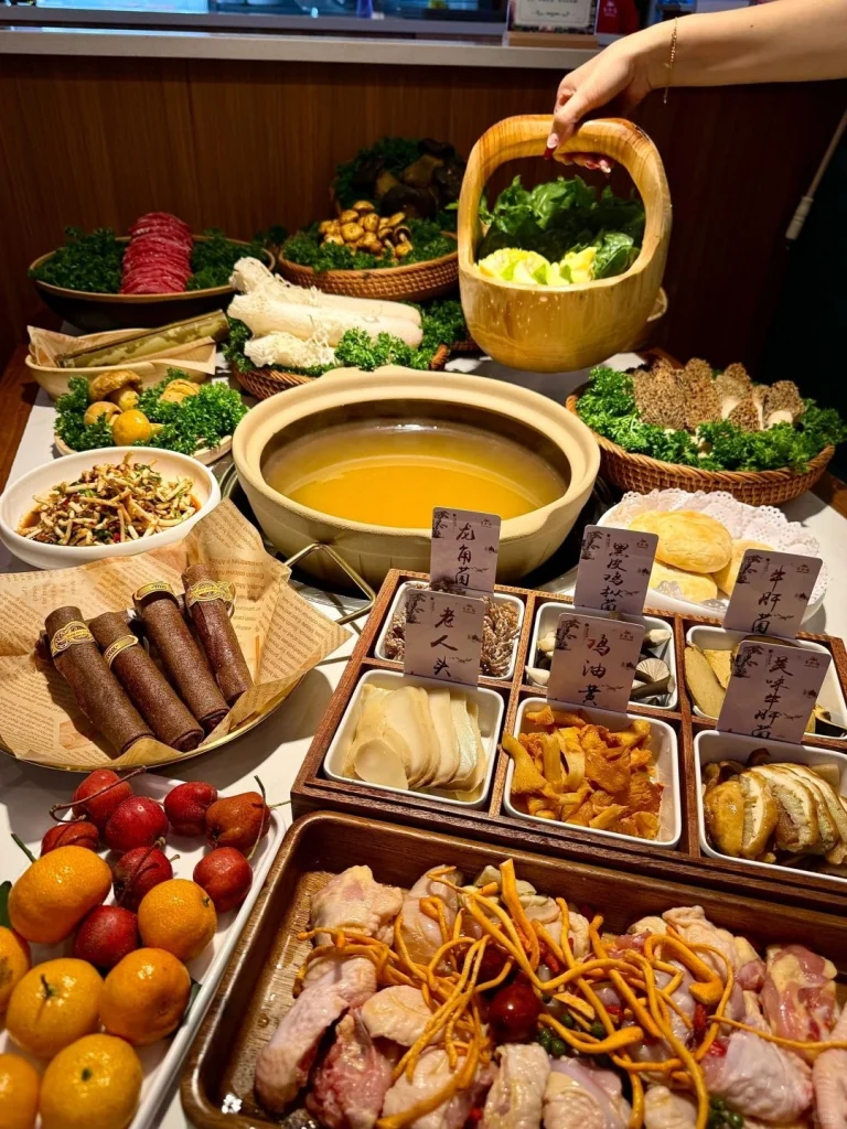 Yunnan mushroom hotpot with various wild mushrooms greens and vegetables served alongside the pot