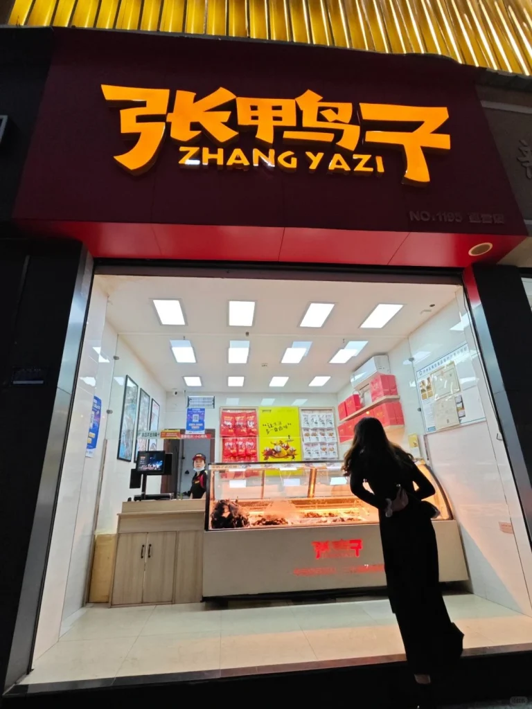 Zhang Yazi restaurant exterior with a customer admiring the store sign