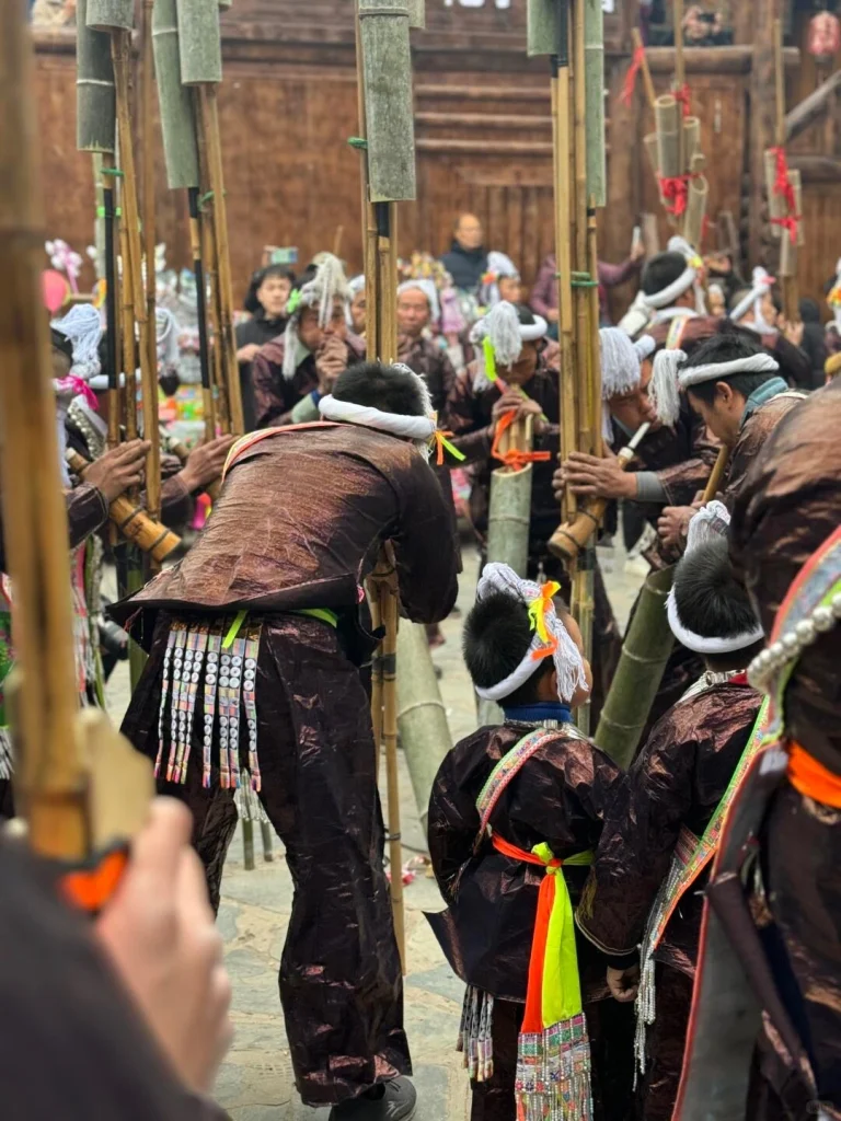 Basha Lusheng Festival Miao villagers performing traditional lusheng dance in ceremonial attire, bamboo instruments raised amid festive crowds in a wooden village square - Chinese Holidays and Festivals in 2026: Dates, Traditions & Travel Guide - The China Journey Basha Lusheng Festival Miao villagers performing traditional lusheng dance in ceremonial attire, bamboo instruments raised amid festive crowds in a wooden village square - Chinese Holidays and Festivals in 2026: Dates, Traditions & Travel Guide - The China Journey
