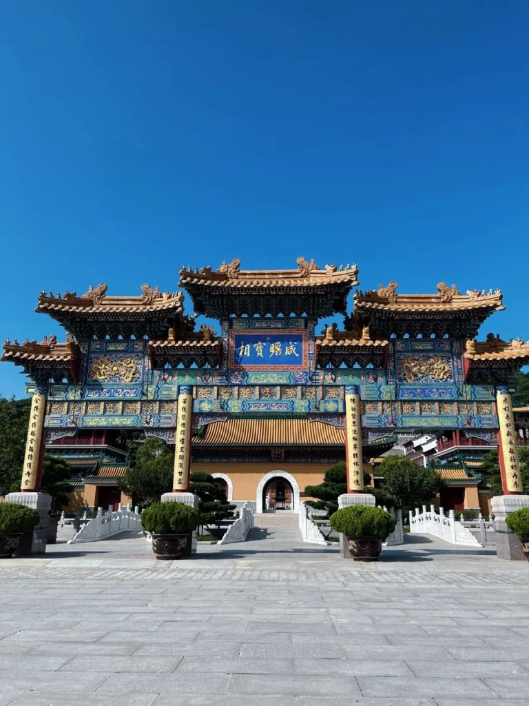Colorful archway at Puji Temple Ornate temple gate with intricate blue and gold patterns and red doors at Mount Putuo