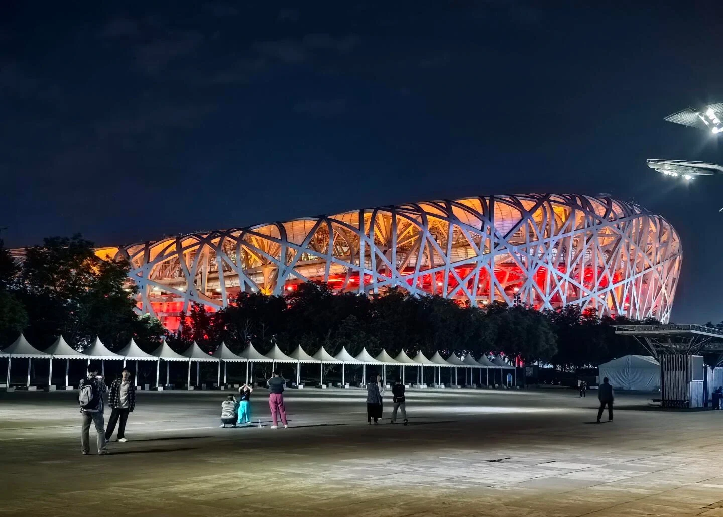 Natudsigt over Beijings Nationalstadion, Fuglereden, oplyst med rødt og orange lys, mens mennesker tager billeder udenfor - Hvor mange dage i Beijing? Den bedste rejselængde 2026 - The China Journey Natudsigt over Beijings Nationalstadion, Fuglereden, oplyst med rødt og orange lys, mens mennesker tager billeder udenfor - Hvor mange dage i Beijing? Den bedste rejselængde 2026 - The China Journey