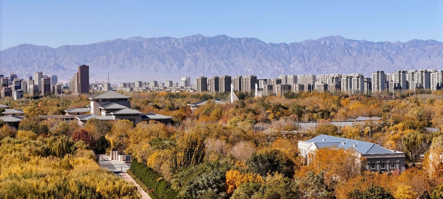 Paisaje urbano de Ningxia en otoño. Una vista panorámica del paisaje urbano de Ningxia con coloridos árboles otoñales y el telón de fondo de las montañas. Ningxia, Jiangnan en la frontera y tierra de pescado y arroz 2026. El viaje a China. Provincias de China. Descubre la cultura y el patrimonio regional. El viaje a China. Paisaje urbano de Ningxia en otoño. Una vista panorámica del paisaje urbano de Ningxia con coloridos árboles otoñales y el telón de fondo de las montañas. Ningxia, Jiangnan en la frontera y tierra de pescado y arroz 2026. El viaje a China. Provincias de China. Descubre la cultura y el patrimonio regional. El viaje a China.