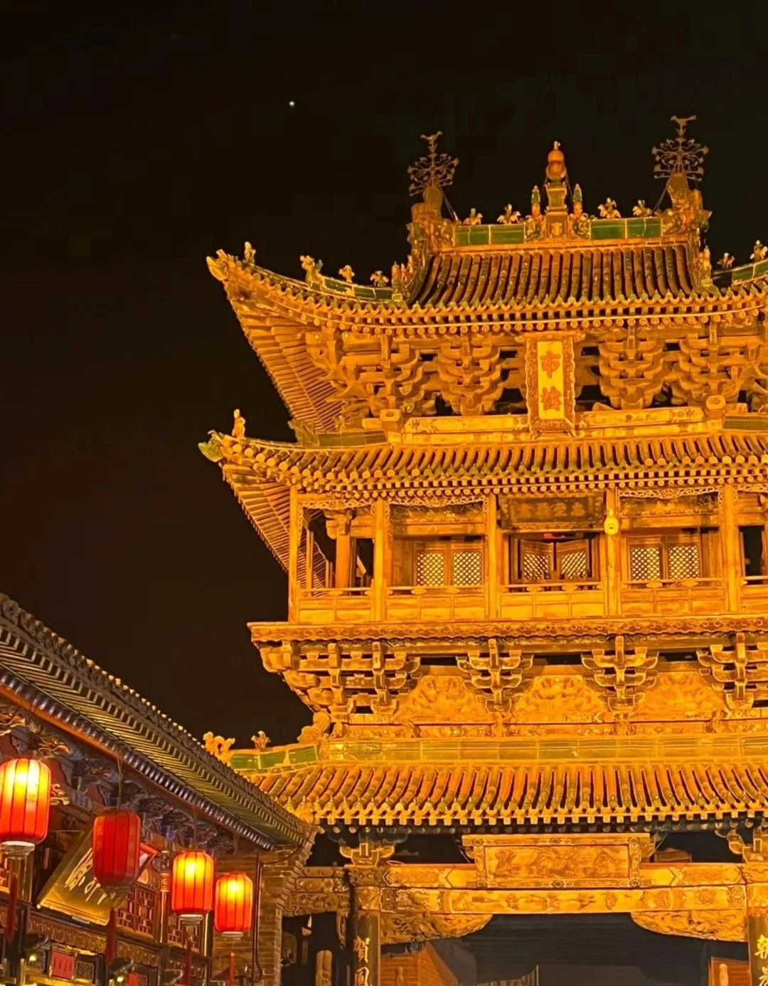 Torre della città di Pingyao di notte. La torre è splendidamente illuminata da luci dorate, circondata da vivaci lanterne rosse e da edifici storici - Guida di viaggio dello Shanxi: itinerari, consigli e luoghi da non perdere 2026 - The China Journey Torre della città di Pingyao di notte. La torre è splendidamente illuminata da luci dorate, circondata da vivaci lanterne rosse e da edifici storici - Guida di viaggio dello Shanxi: itinerari, consigli e luoghi da non perdere 2026 - The China Journey
