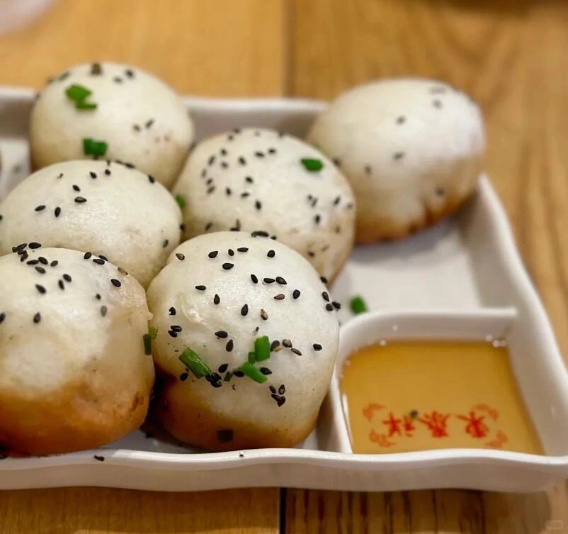 Klassieke Shengjian-dumplings met dipsaus – Traditionele Shanghai-stijl gebakken broodjes geserveerd met zwarte sesam, lente-uitjes en een hartige dipsaus. - Wat is het populairste gerecht in Shanghai, China? 2026 - De reis door China Klassieke Shengjian-dumplings met dipsaus – Traditionele Shanghai-stijl gebakken broodjes geserveerd met zwarte sesam, lente-uitjes en een hartige dipsaus. - Wat is het populairste gerecht in Shanghai, China? 2026 - De reis door China
