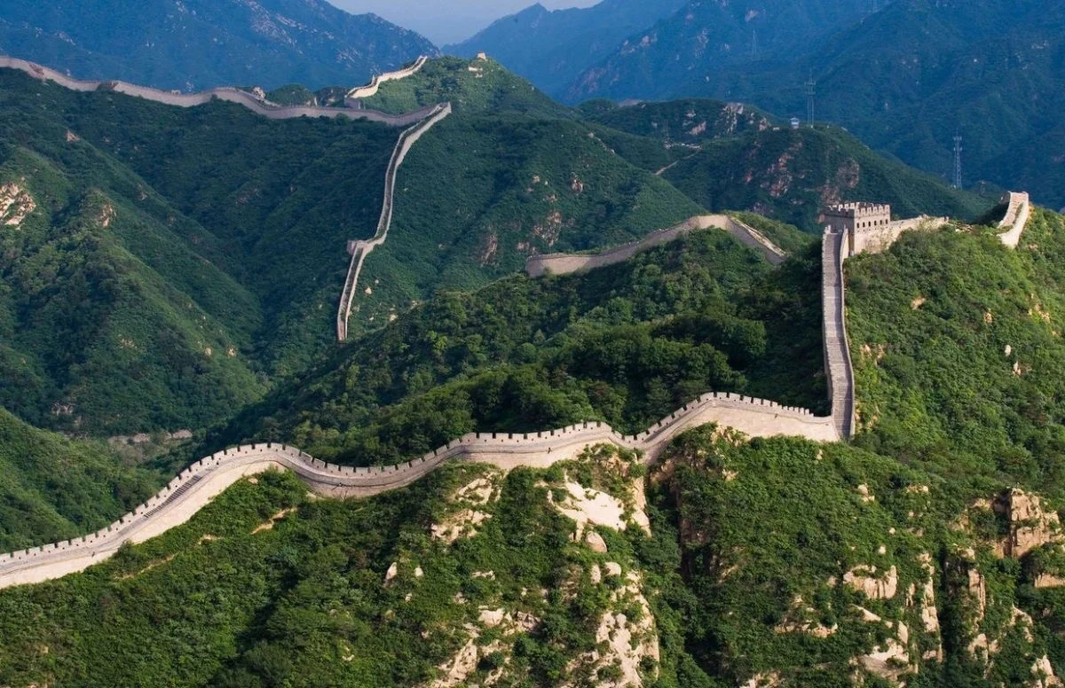 Gran Muralla China, Badaling. Una vista panorámica del tramo de Badaling de la Gran Muralla que serpentea entre exuberantes colinas verdes con turistas caminando por el sendero. - 1 día en Pekín: el mejor itinerario corto de 2026 - El viaje a China Gran Muralla China, Badaling. Una vista panorámica del tramo de Badaling de la Gran Muralla que serpentea entre exuberantes colinas verdes con turistas caminando por el sendero. - 1 día en Pekín: el mejor itinerario corto de 2026 - El viaje a China