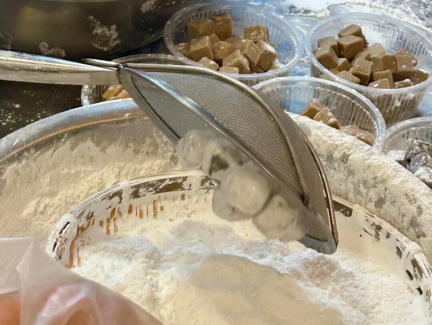 Glutinous rice balls being sifted and rolled during Yuanxiao making.
