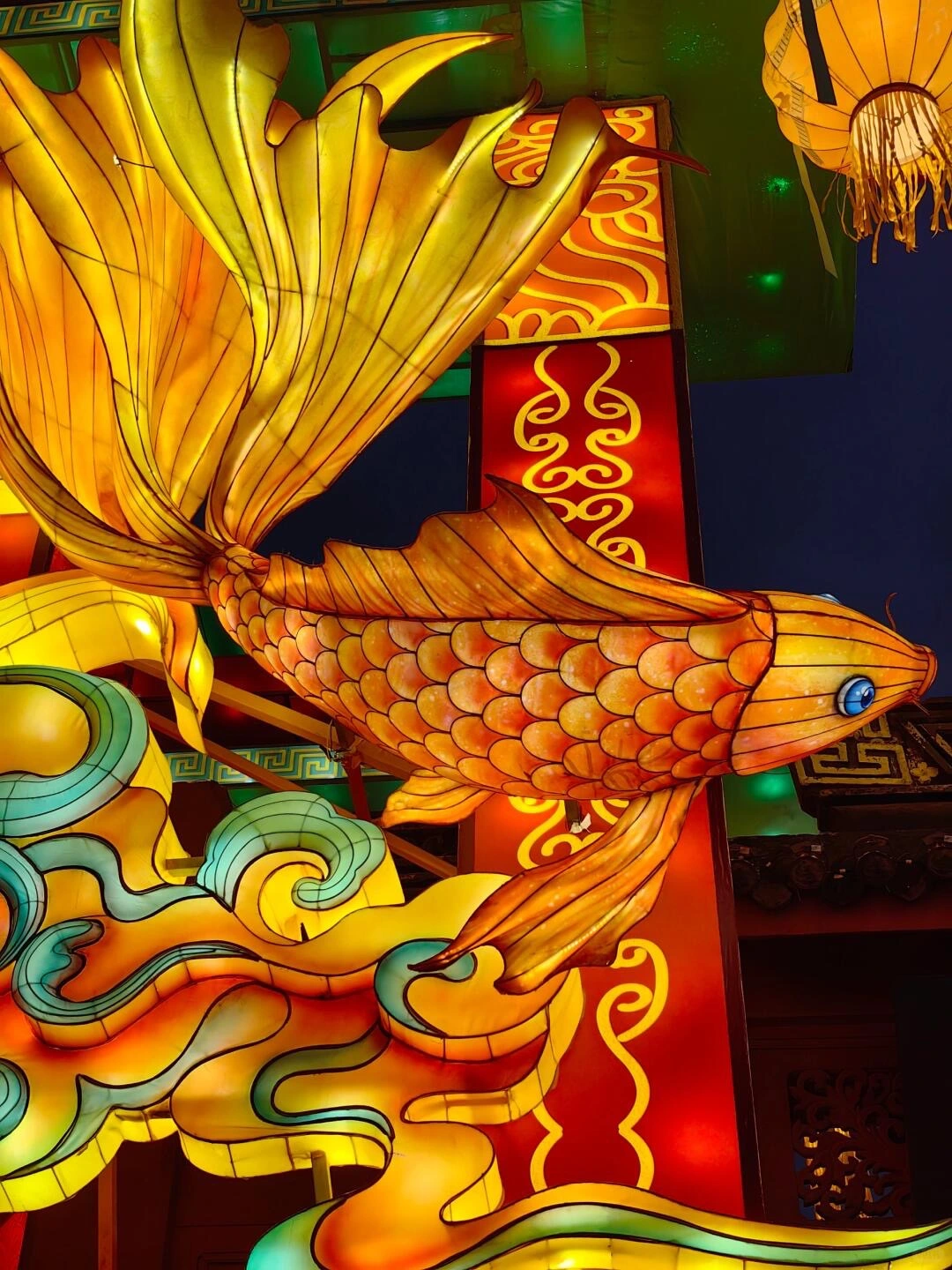 Golden fish lantern with vibrant scales and swirling cloud patterns during Lantern Festival.