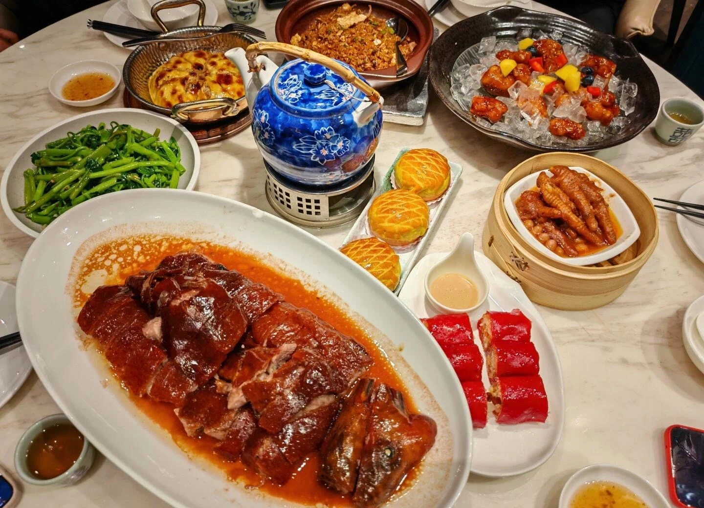 Traditional Guangzhou Cantonese feast with roast goose, dim sum, and assorted dishes on marble table - What to Eat in Guangzhou: Local Food Guide 2026 - The China Journey Traditional Guangzhou Cantonese feast with roast goose, dim sum, and assorted dishes on marble table - What to Eat in Guangzhou: Local Food Guide 2026 - The China Journey