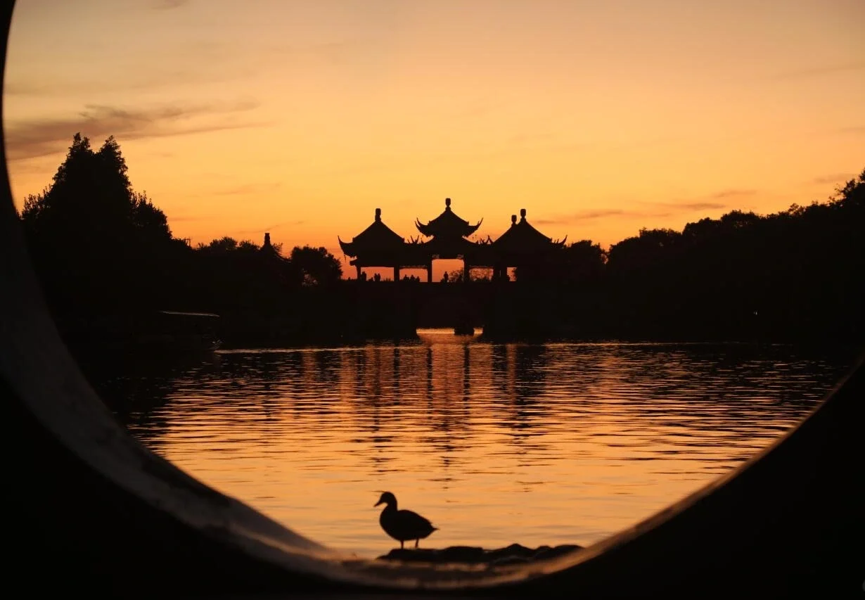 Sunset glow over Slender West Lake in Yangzhou with silhouette of Five Pavilion Bridge - Where to Stay in Yangzhou: Best Areas & Hotels 2026 - The China Journey Sunset glow over Slender West Lake in Yangzhou with silhouette of Five Pavilion Bridge - Where to Stay in Yangzhou: Best Areas & Hotels 2026 - The China Journey