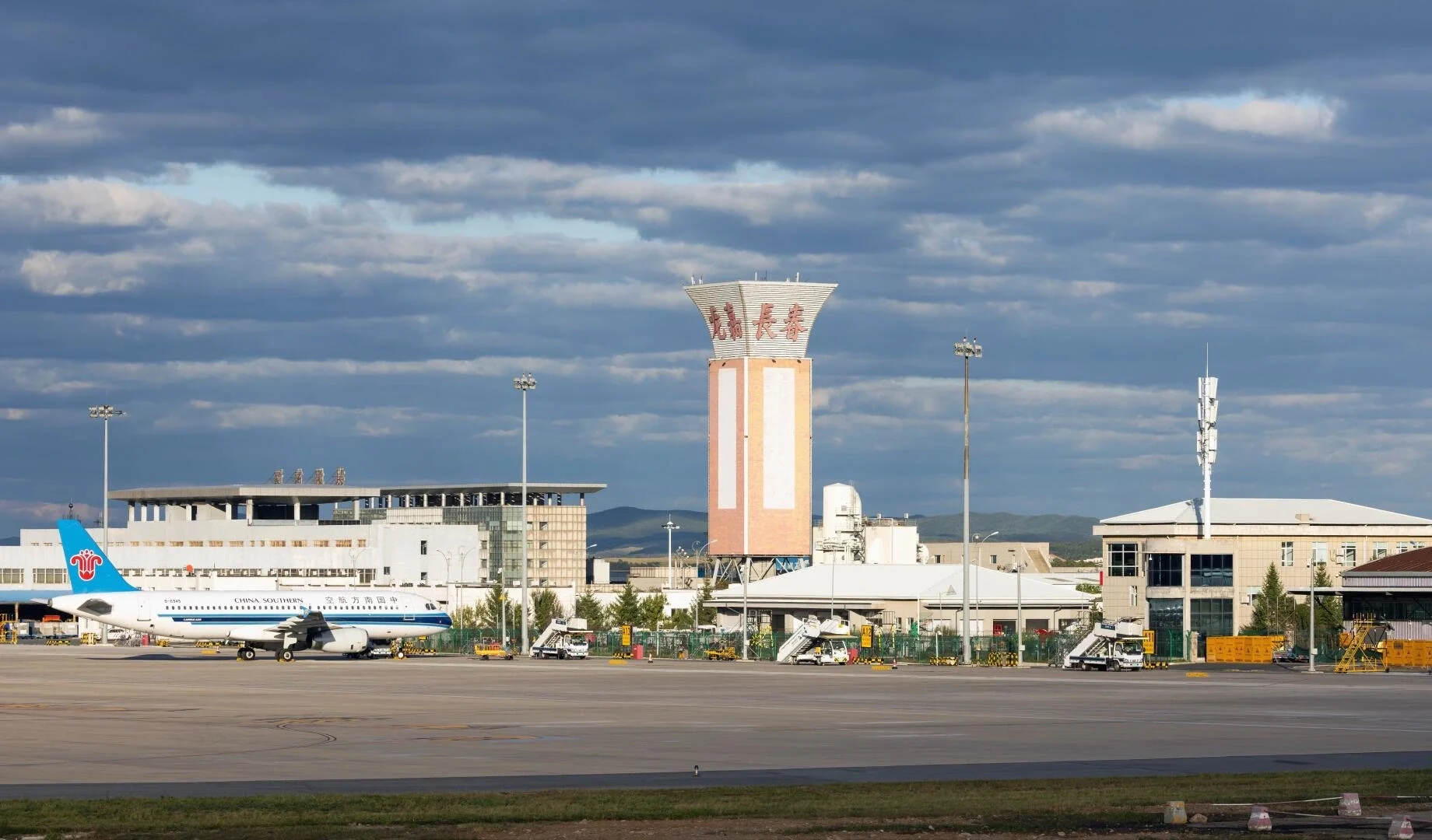 Internationale luchthaven Changchun Longjia – Moderne terminal met vliegtuigen op de startbaan onder een dramatische hemel, de belangrijkste luchttoegang tot de provincie Jilin - Reisgids Changchun: geschiedenis, parken & tips 2026 - The China Journey Internationale luchthaven Changchun Longjia – Moderne terminal met vliegtuigen op de startbaan onder een dramatische hemel, de belangrijkste luchttoegang tot de provincie Jilin - Reisgids Changchun: geschiedenis, parken & tips 2026 - The China Journey
