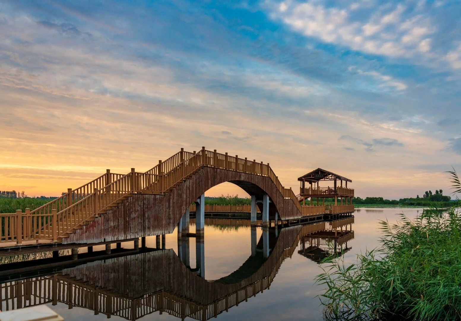 Houten brug in het Baiyangdian-wetland over rustig water dat de hemel weerspiegelt in een vredig landschap - Reisgids voor Hebei: beste routes buiten Beijing 2026 - The China Journey Houten brug in het Baiyangdian-wetland over rustig water dat de hemel weerspiegelt in een vredig landschap - Reisgids voor Hebei: beste routes buiten Beijing 2026 - The China Journey