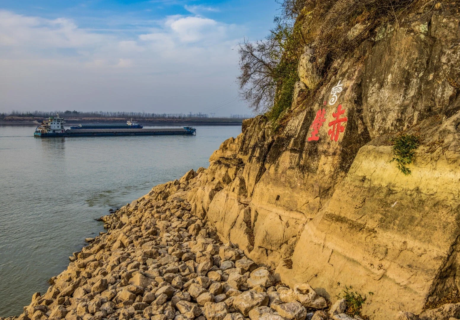 Tebing Merah Chibi di Sungai Yangtze, tebing sungai berbatu dengan aksara Cina merah menghadap sungai dan kapal kargo yang lalu - Panduan Perjalanan Hubei: Laluan, Petua & Jadual Perjalanan 2026 - The China Journey Tebing Merah Chibi di Sungai Yangtze, tebing sungai berbatu dengan aksara Cina merah menghadap sungai dan kapal kargo yang lalu - Panduan Perjalanan Hubei: Laluan, Petua & Jadual Perjalanan 2026 - The China Journey