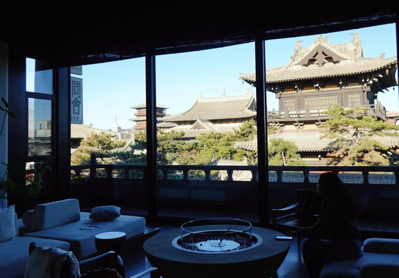 Vista del cortile tradizionale di Datong: edifici in legno in stile cinese visti attraverso la finestra dall'interno accogliente di una pensione nello Shanxi - Guida di viaggio dello Shanxi: itinerari, consigli e luoghi da non perdere 2026 - The China Journey Vista del cortile tradizionale di Datong: edifici in legno in stile cinese visti attraverso la finestra dall'interno accogliente di una pensione nello Shanxi - Guida di viaggio dello Shanxi: itinerari, consigli e luoghi da non perdere 2026 - The China Journey