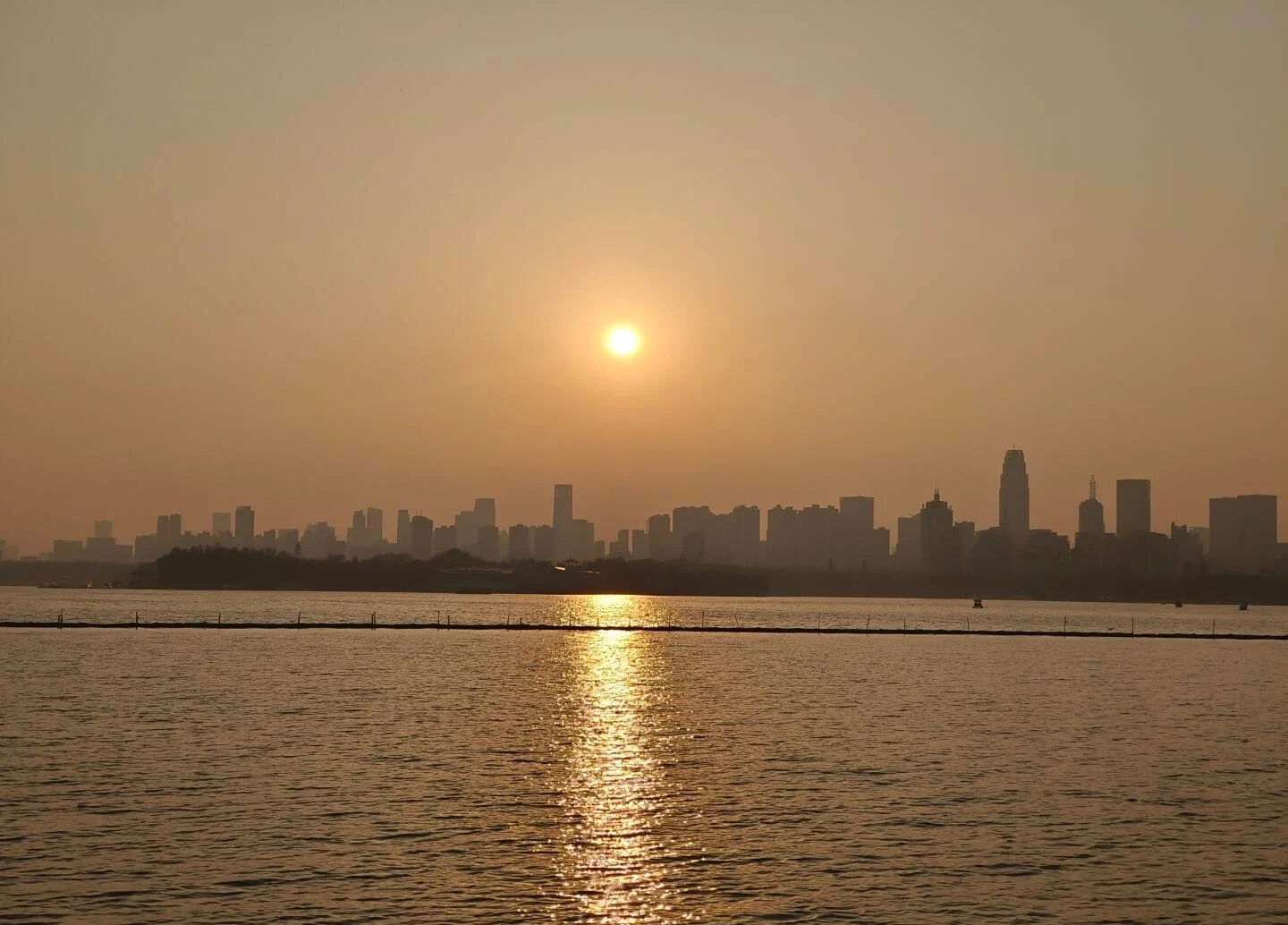 Pemandangan Matahari Terbenam Wuhan dari Tasik Timur, cahaya emas memantul pada air tasik tenang dengan siluet latar langit bandar - Panduan Perjalanan Hubei: Laluan, Petua & Jadual Perjalanan 2026 - The China Journey Pemandangan Matahari Terbenam Wuhan dari Tasik Timur, cahaya emas memantul pada air tasik tenang dengan siluet latar langit bandar - Panduan Perjalanan Hubei: Laluan, Petua & Jadual Perjalanan 2026 - The China Journey