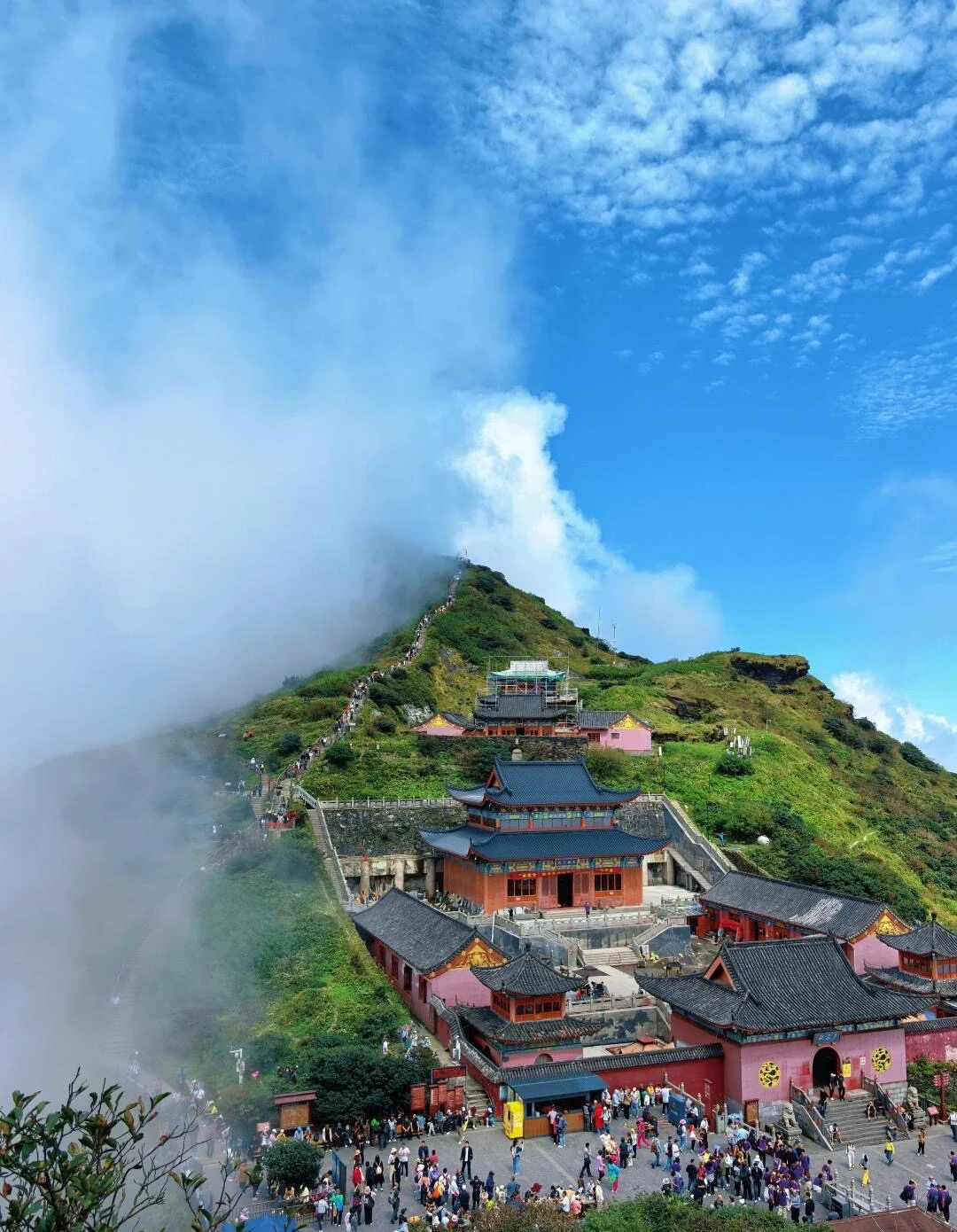 Fanjingshan dağ tapınağı görünümü; bulutların arasında dik dağ sırtındaki Budist tapınakları ve manzara yolunda yürüyen ziyaretçiler - Guizhou Gezi Rehberi: Rotalar, İpuçları ve Gezi Planları 2026 - The China Journey Fanjingshan dağ tapınağı görünümü; bulutların arasında dik dağ sırtındaki Budist tapınakları ve manzara yolunda yürüyen ziyaretçiler - Guizhou Gezi Rehberi: Rotalar, İpuçları ve Gezi Planları 2026 - The China Journey