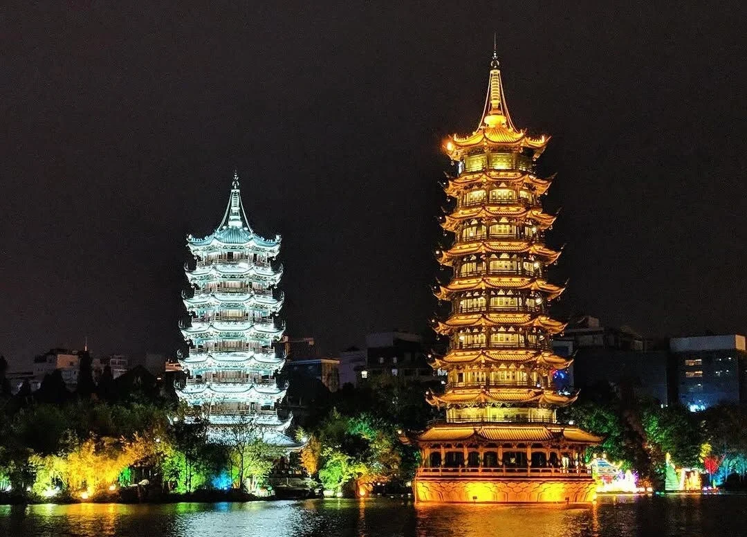 Guilin Güneş ve Ay Pagodaları gece görünümü; canlı şehir ışıklarıyla göle yansıyan aydınlatılmış ikiz pagodalar - Guangxi Seyahat Rehberi: En İyi Rotalar, İpuçları ve Gezi Planları 2026 - The China Journey Guilin Güneş ve Ay Pagodaları gece görünümü; canlı şehir ışıklarıyla göle yansıyan aydınlatılmış ikiz pagodalar - Guangxi Seyahat Rehberi: En İyi Rotalar, İpuçları ve Gezi Planları 2026 - The China Journey
