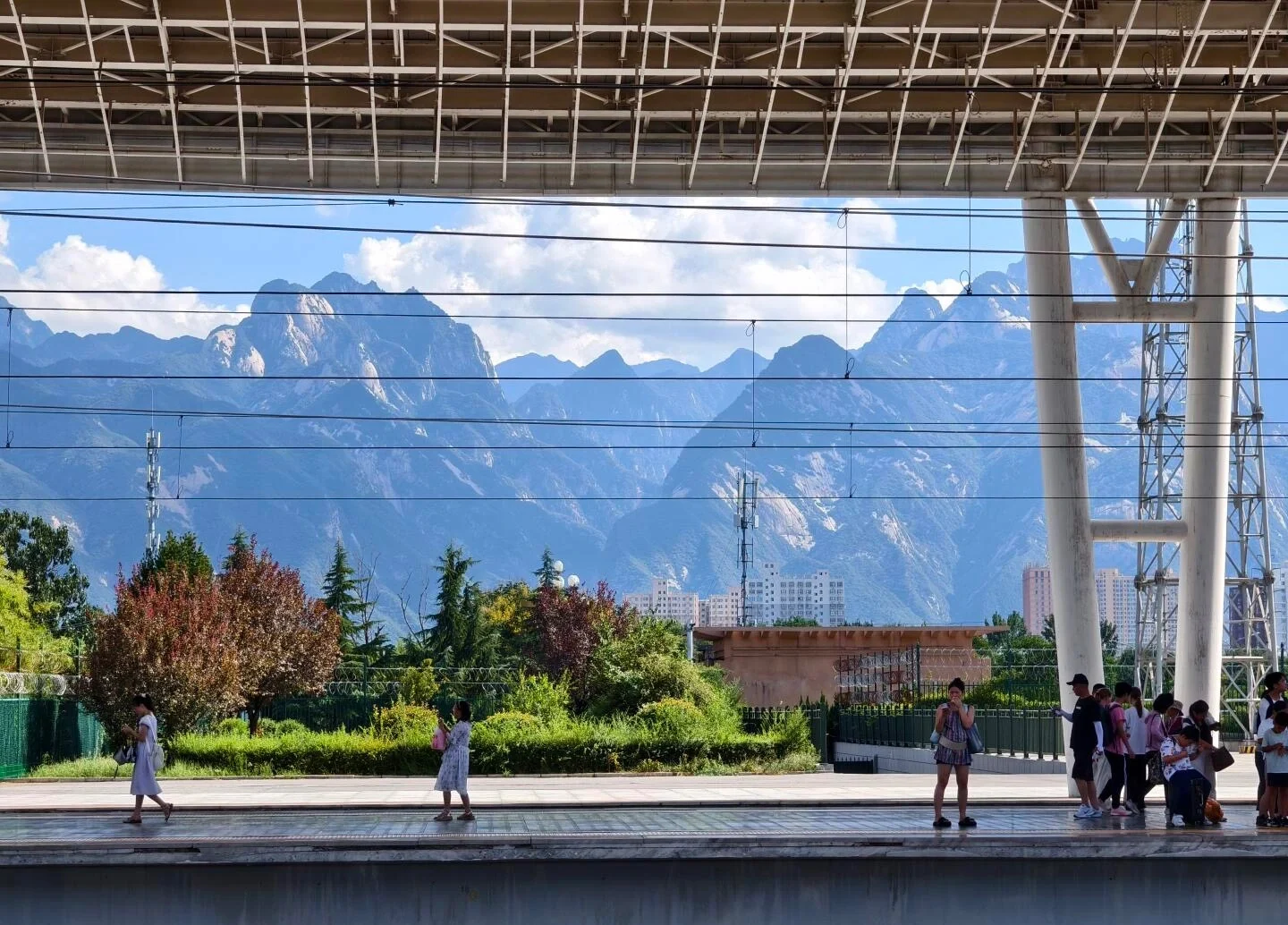 Huashan North Railway Station View – visitors waiting on platform with Mount Huashan peaks in background - Mount Huashan Travel Guide: Best Routes, Tips & Day Trip 2026 - The China Journey Huashan North Railway Station View – visitors waiting on platform with Mount Huashan peaks in background - Mount Huashan Travel Guide: Best Routes, Tips & Day Trip 2026 - The China Journey