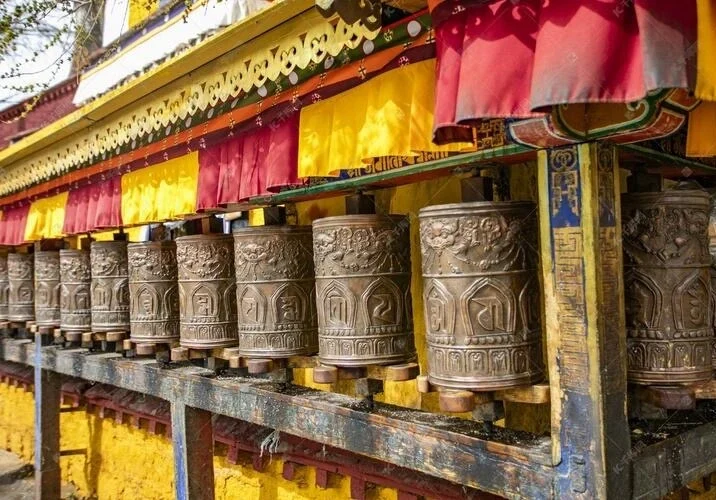 Fila de ruedas de oración del Templo de Jokhang, ruedas tradicionales de bronce alineadas en el corredor para los peregrinos de Lhasa - Guía de viaje al Tíbet: mejores rutas, consejos e itinerarios 2026 - The China Journey Fila de ruedas de oración del Templo de Jokhang, ruedas tradicionales de bronce alineadas en el corredor para los peregrinos de Lhasa - Guía de viaje al Tíbet: mejores rutas, consejos e itinerarios 2026 - The China Journey