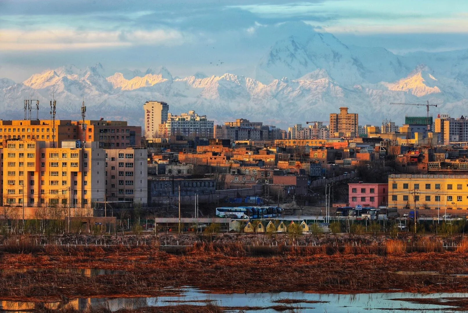 Kunlun Dağları ile Kaşgar Şehri – uzaktaki karla kaplı dağ sıralarıyla çevrelenmiş çöl vahası şehir silüeti - Xinjiang Seyahat Rehberi: En İyi Rotalar ve Yerler 2026 - Çin Yolculuğu Kunlun Dağları ile Kaşgar Şehri – uzaktaki karla kaplı dağ sıralarıyla çevrelenmiş çöl vahası şehir silüeti - Xinjiang Seyahat Rehberi: En İyi Rotalar ve Yerler 2026 - Çin Yolculuğu