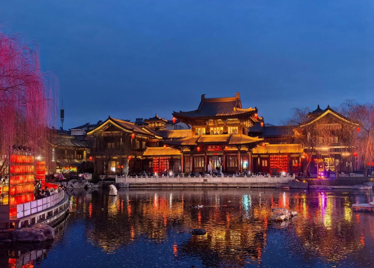 Vista notturna dell'antica città di Luoyi: edifici tradizionali cinesi illuminati da lanterne che si riflettono sull'acqua calma di notte - Guida di viaggio dell'Henan: i migliori itinerari per una prima visita 2026 - The China Journey Vista notturna dell'antica città di Luoyi: edifici tradizionali cinesi illuminati da lanterne che si riflettono sull'acqua calma di notte - Guida di viaggio dell'Henan: i migliori itinerari per una prima visita 2026 - The China Journey