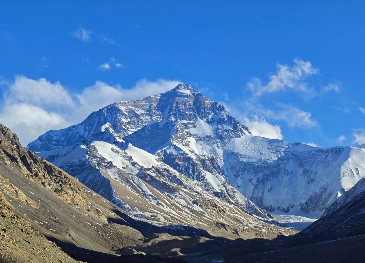 Vista de la cara norte del monte Everest, enorme cumbre nevada que se eleva sobre un valle rocoso bajo un cielo azul intenso en el Tíbet - Guía de viaje al Tíbet: mejores rutas, consejos e itinerarios 2026 - The China Journey Vista de la cara norte del monte Everest, enorme cumbre nevada que se eleva sobre un valle rocoso bajo un cielo azul intenso en el Tíbet - Guía de viaje al Tíbet: mejores rutas, consejos e itinerarios 2026 - The China Journey