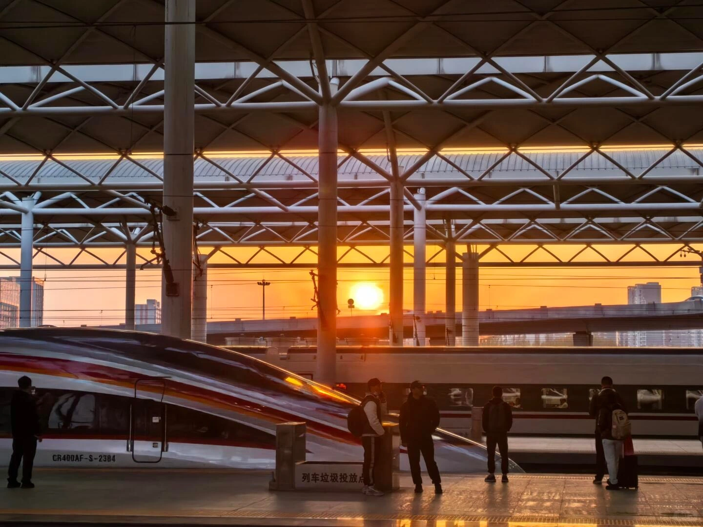 Reizigers bij het treinstation van Shijiazhuang, met silhouetten op een hogesnelheidstreinperron in warm zonsondergangslicht - Reisgids voor Hebei: beste routes buiten Beijing 2026 - The China Journey Reizigers bij het treinstation van Shijiazhuang, met silhouetten op een hogesnelheidstreinperron in warm zonsondergangslicht - Reisgids voor Hebei: beste routes buiten Beijing 2026 - The China Journey