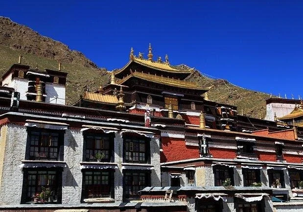 Arquitectura del monasterio de Tashilhunpo con tejados dorados y muros blancos bajo un cielo azul intenso en Shigatse - Guía de viaje al Tíbet: mejores rutas, consejos e itinerarios 2026 - The China Journey Arquitectura del monasterio de Tashilhunpo con tejados dorados y muros blancos bajo un cielo azul intenso en Shigatse - Guía de viaje al Tíbet: mejores rutas, consejos e itinerarios 2026 - The China Journey