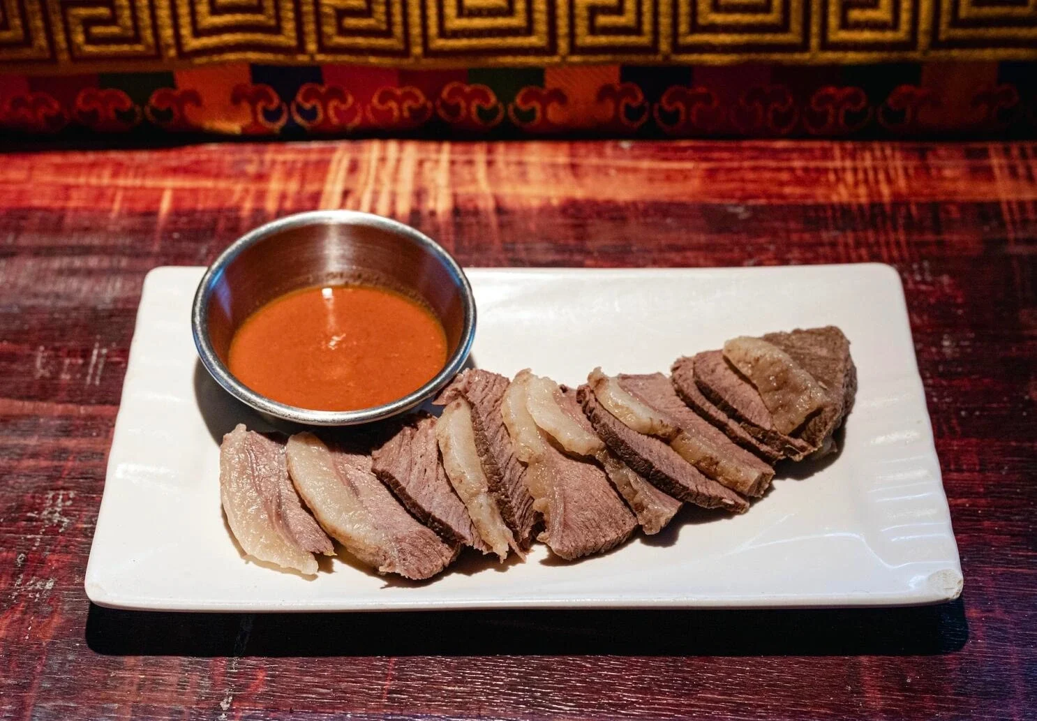 Plato tibetano de carne de yak, con lonchas servidas con salsa para mojar en un plato tradicional dentro de un restaurante tibetano - Guía de viaje al Tíbet: mejores rutas, consejos e itinerarios 2026 - The China Journey Plato tibetano de carne de yak, con lonchas servidas con salsa para mojar en un plato tradicional dentro de un restaurante tibetano - Guía de viaje al Tíbet: mejores rutas, consejos e itinerarios 2026 - The China Journey