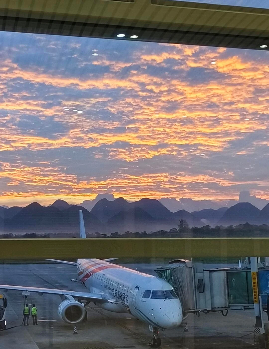 Xingyi Wanfenglin Havalimanı'nda gün batımı; terminal yakınında park etmiş uçak, dramatik gün batımı bulutları ve dağ silüetleri - Guizhou Gezi Rehberi: Rotalar, İpuçları ve Gezi Planları 2026 - The China Journey Xingyi Wanfenglin Havalimanı'nda gün batımı; terminal yakınında park etmiş uçak, dramatik gün batımı bulutları ve dağ silüetleri - Guizhou Gezi Rehberi: Rotalar, İpuçları ve Gezi Planları 2026 - The China Journey