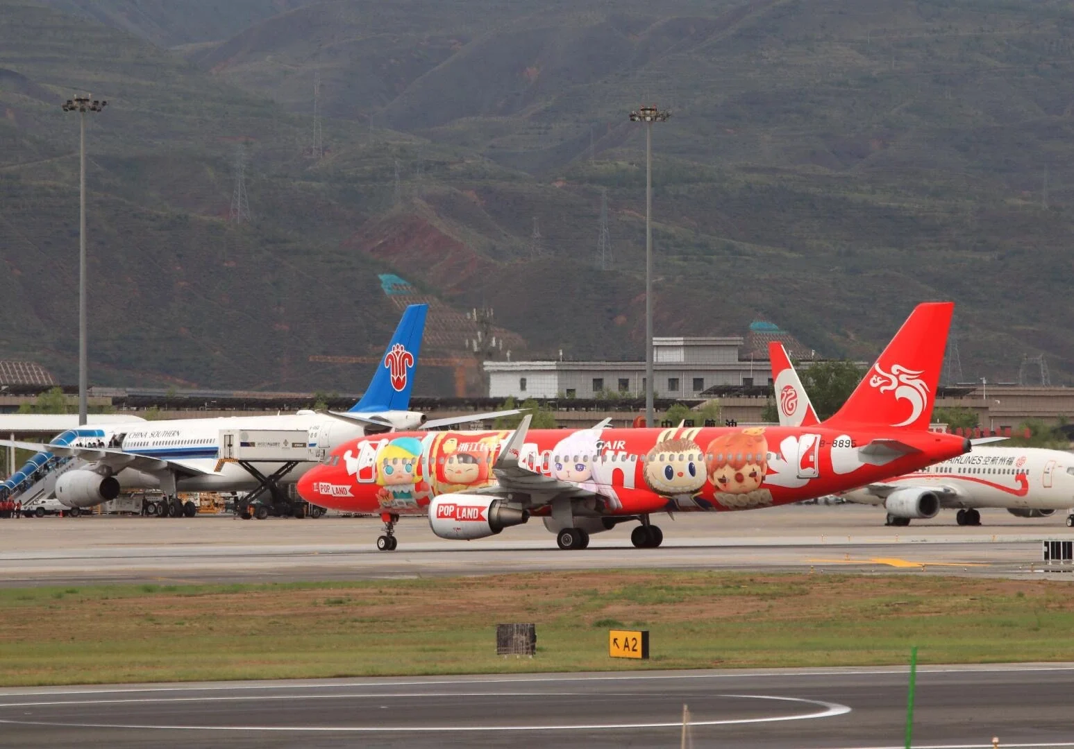 Start- und Landebahn des Flughafens Xining Caojiabao, farbige Flugzeuge vor Bergen auf dem Rollfeld – Qinghai-Reiseführer: Reiseziele, Routen & Tipps 2026 – The China Journey Start- und Landebahn des Flughafens Xining Caojiabao, farbige Flugzeuge vor Bergen auf dem Rollfeld – Qinghai-Reiseführer: Reiseziele, Routen & Tipps 2026 – The China Journey