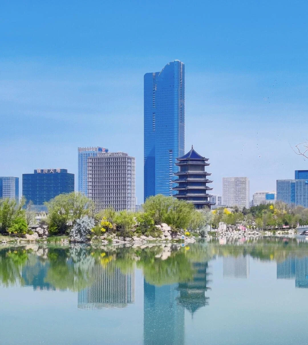Yinchuan CBD Skyline and Lake Reflection Modern skyscrapers and pagoda reflected on calm urban lake in Ningxia city - Ningxia Travel Guide: Routes, Desert & Culture 2026 - The China Journey Yinchuan CBD Skyline and Lake Reflection Modern skyscrapers and pagoda reflected on calm urban lake in Ningxia city - Ningxia Travel Guide: Routes, Desert & Culture 2026 - The China Journey