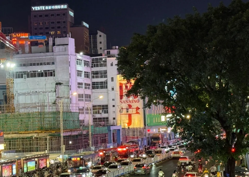 Chaoyang Square Night Traffic Busy downtown street with cars lights and buildings reflecting lively Nanning nightlife
