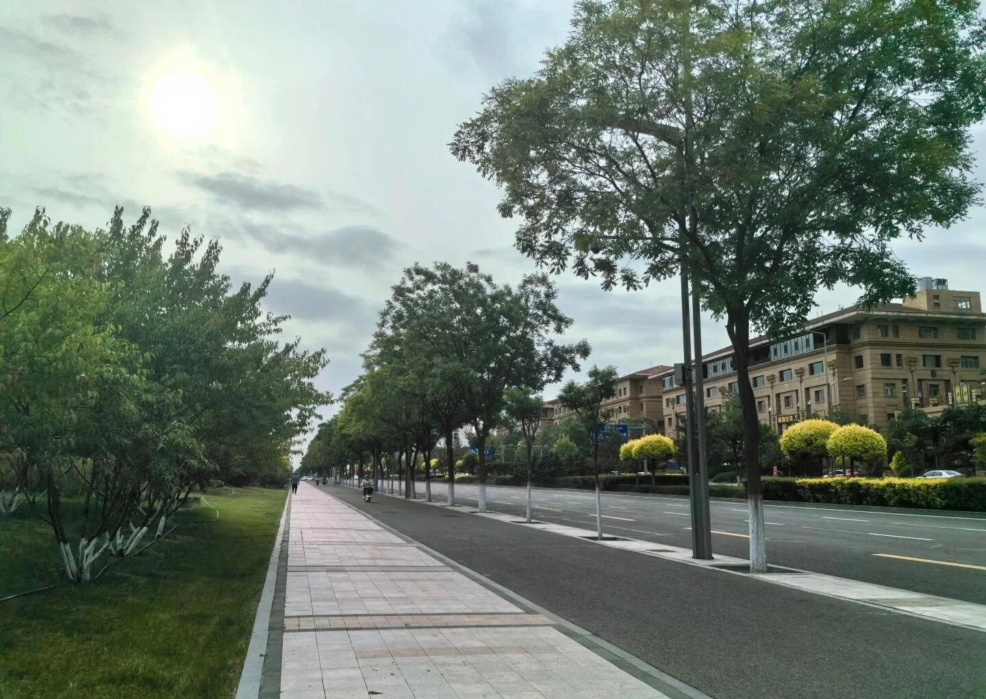 Paesaggio urbano del nuovo distretto di Datong Yudong: ampio viale alberato con moderni edifici residenziali e percorso pedonale illuminato da una luce soffusa - Dove alloggiare a Datong: migliori zone e hotel 2026 - The China Journey Paesaggio urbano del nuovo distretto di Datong Yudong: ampio viale alberato con moderni edifici residenziali e percorso pedonale illuminato da una luce soffusa - Dove alloggiare a Datong: migliori zone e hotel 2026 - The China Journey