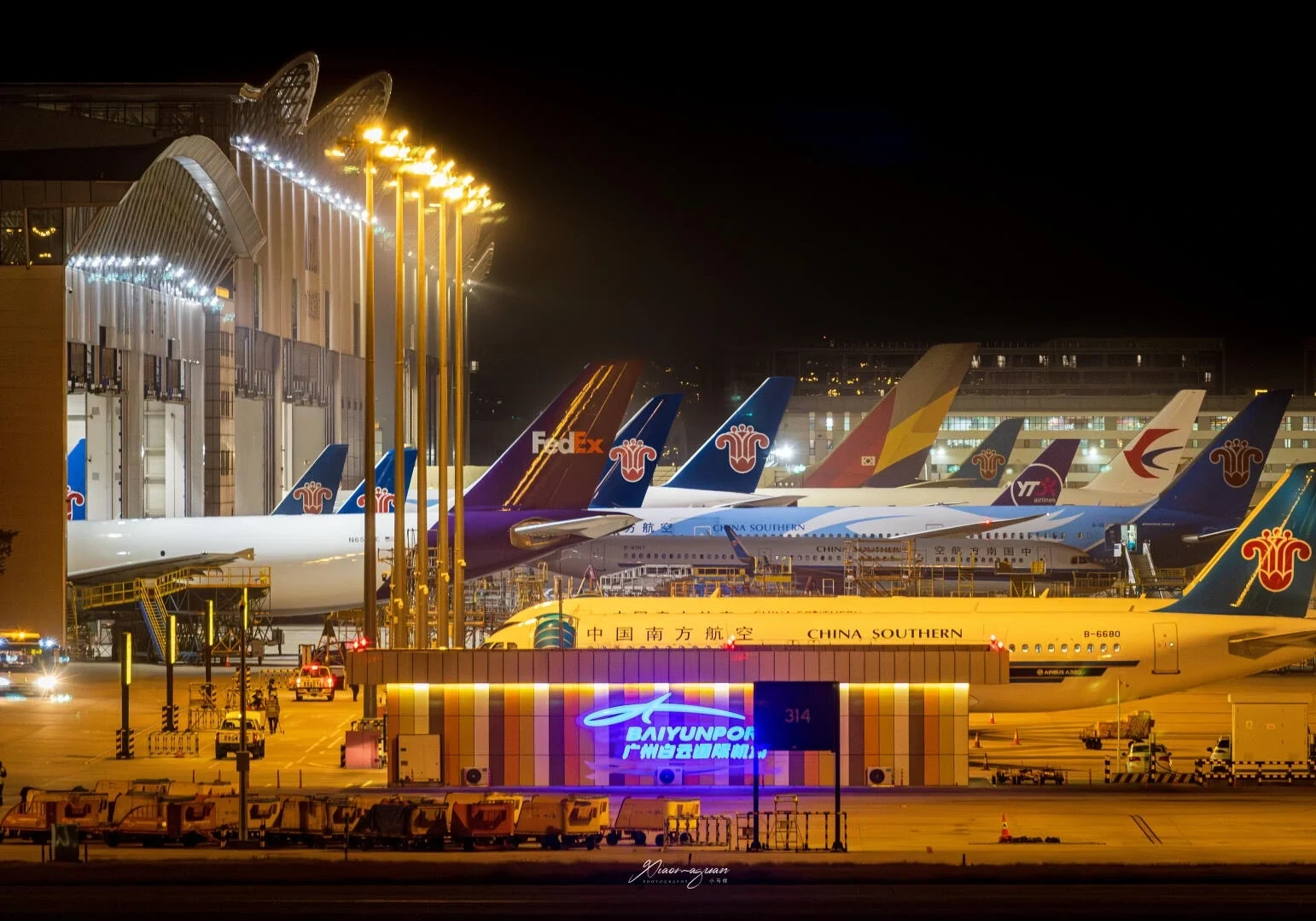 Vliegtuigen in de avond op Guangzhou Baiyun Airport, met toestellen van meerdere maatschappijen, felle baanverlichting en een druk luchtvaartknooppunt - Reisgids voor Foshan: beste routes, eten en tips 2026 - The China Journey Vliegtuigen in de avond op Guangzhou Baiyun Airport, met toestellen van meerdere maatschappijen, felle baanverlichting en een druk luchtvaartknooppunt - Reisgids voor Foshan: beste routes, eten en tips 2026 - The China Journey