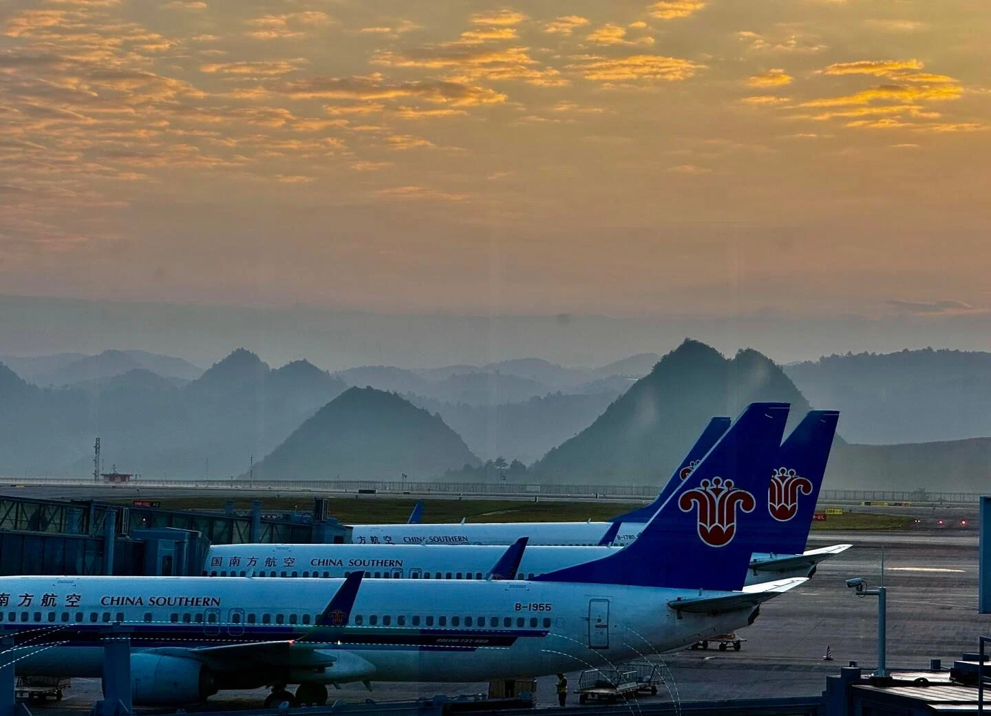 Guiyang Longdongbao Airport Sunset Runway China Southern airplanes parked with mountains and golden sky at airport terminal - Where to Stay in Guiyang: Best Areas & Hotels 2026 - The China Journey Guiyang Longdongbao Airport Sunset Runway China Southern airplanes parked with mountains and golden sky at airport terminal - Where to Stay in Guiyang: Best Areas & Hotels 2026 - The China Journey
