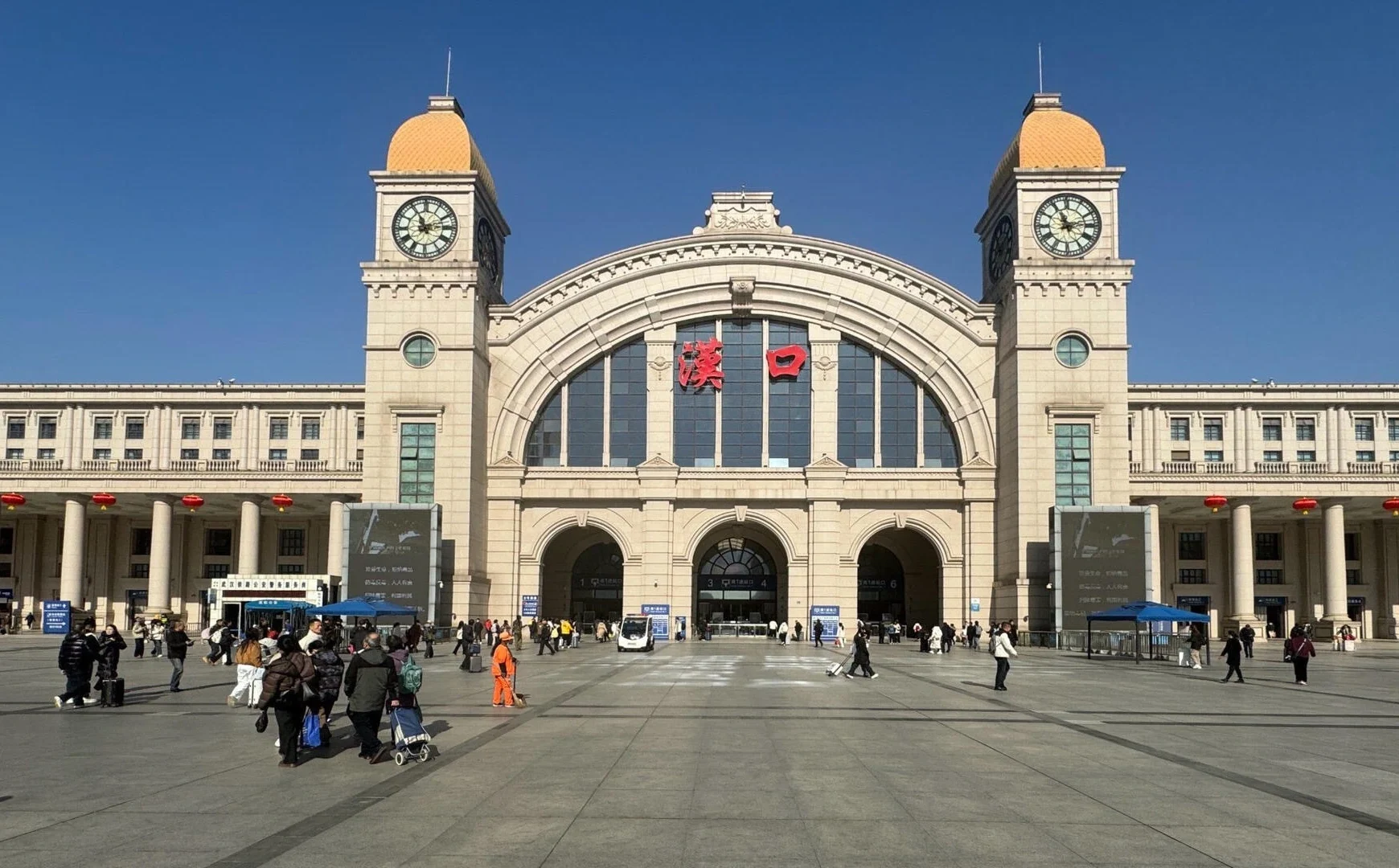 Hankou Railway Station Wuhan Grand historic train station facade with clock towers and travelers entering busy transport hub - Where to Stay in Wuhan: Best Areas & Hotels 2026 - The China Journey Hankou Railway Station Wuhan Grand historic train station facade with clock towers and travelers entering busy transport hub - Where to Stay in Wuhan: Best Areas & Hotels 2026 - The China Journey