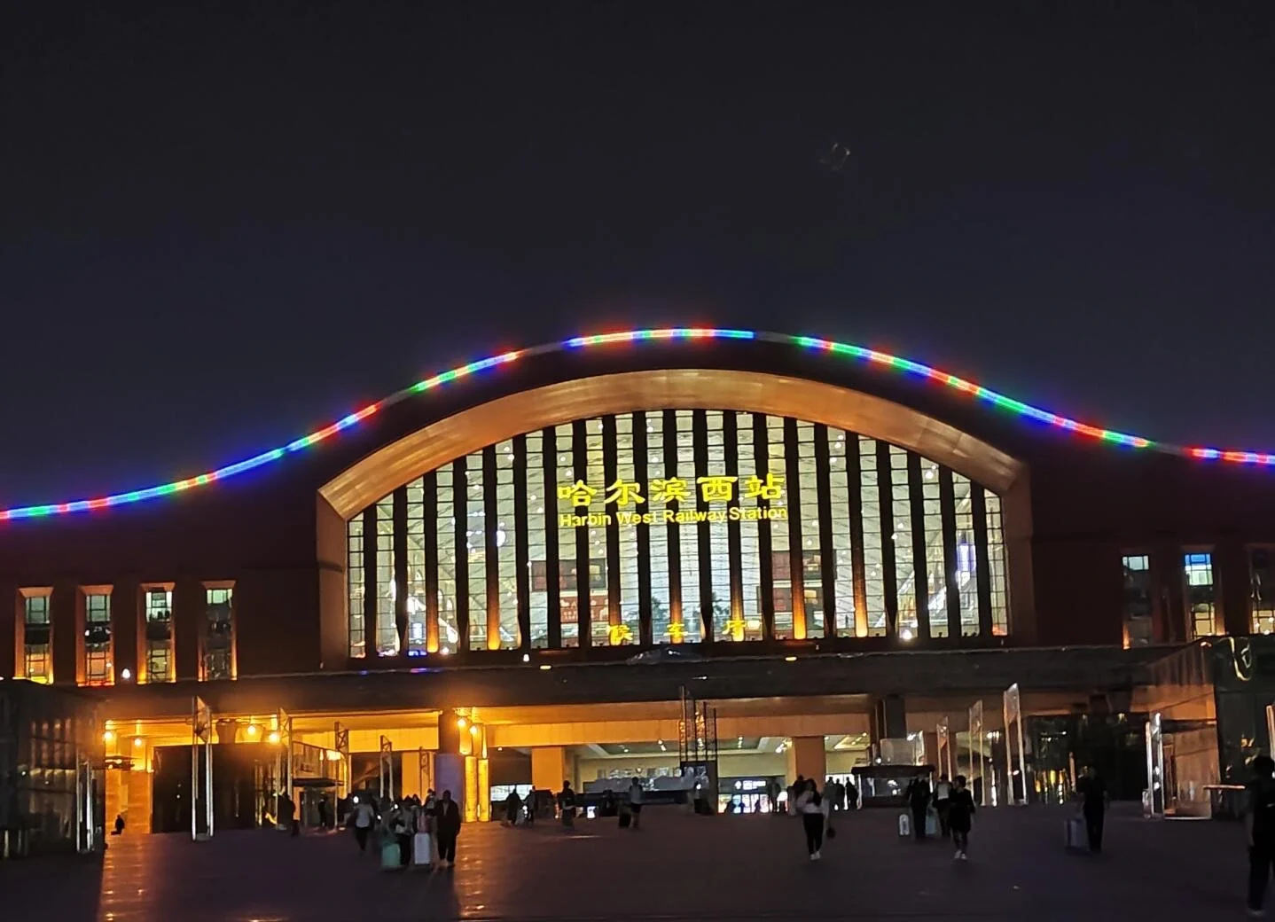 Harbin Batı Tren İstasyonu Gece Işıkları: Renkli ışıklarla aydınlatılmış modern istasyon girişi ve gece gelen yolcular - Harbin'de Nerede Kalınır: En İyi Bölgeler ve Oteller 2026 - The China Journey Harbin Batı Tren İstasyonu Gece Işıkları: Renkli ışıklarla aydınlatılmış modern istasyon girişi ve gece gelen yolcular - Harbin'de Nerede Kalınır: En İyi Bölgeler ve Oteller 2026 - The China Journey