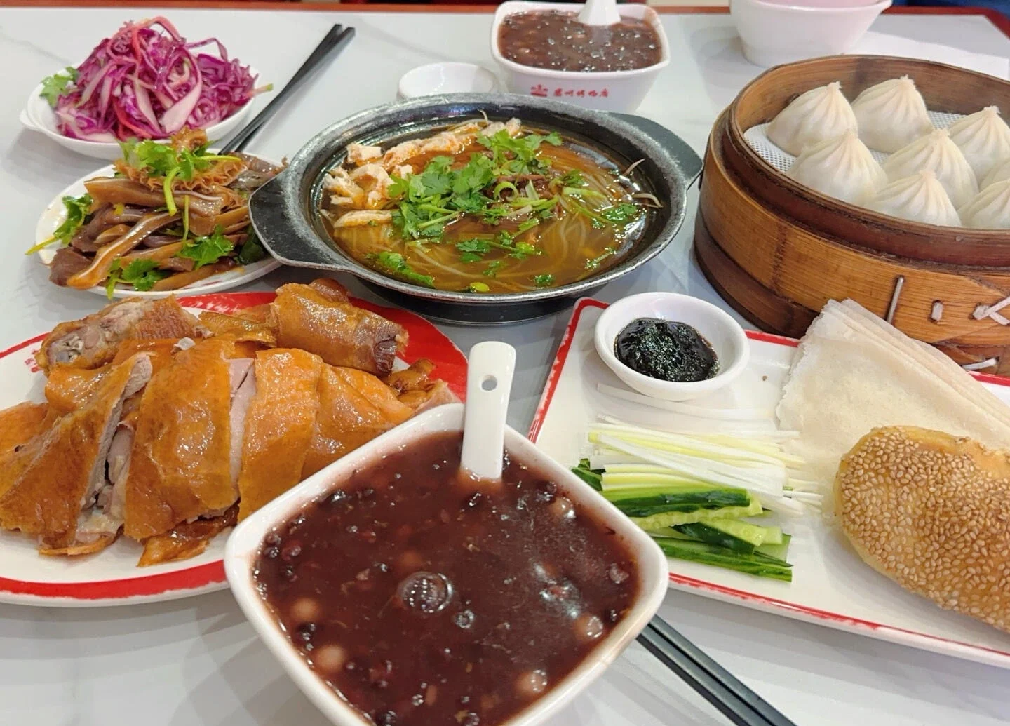 Table garnie de canard rôti de Luzhou, raviolis, nouilles et spécialités locales de Hefei - Guide de voyage de Hefei : visites, gastronomie et conseils 2026 - The China Journey Table garnie de canard rôti de Luzhou, raviolis, nouilles et spécialités locales de Hefei - Guide de voyage de Hefei : visites, gastronomie et conseils 2026 - The China Journey