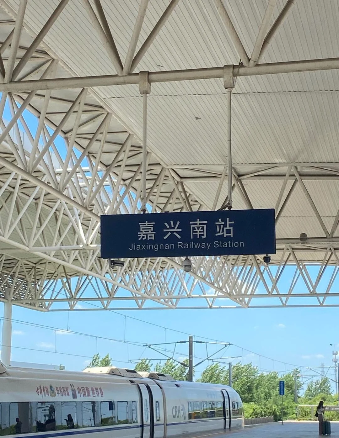 Perronzicht bij station Jiaxingnan, een modern hogesnelheidsstation met bewegwijzering en een gestroomlijnde trein onder een helderblauwe hemel - Reisgids voor Jiaxing: waterstadjes, routes en tips 2026 - The China Journey Perronzicht bij station Jiaxingnan, een modern hogesnelheidsstation met bewegwijzering en een gestroomlijnde trein onder een helderblauwe hemel - Reisgids voor Jiaxing: waterstadjes, routes en tips 2026 - The China Journey