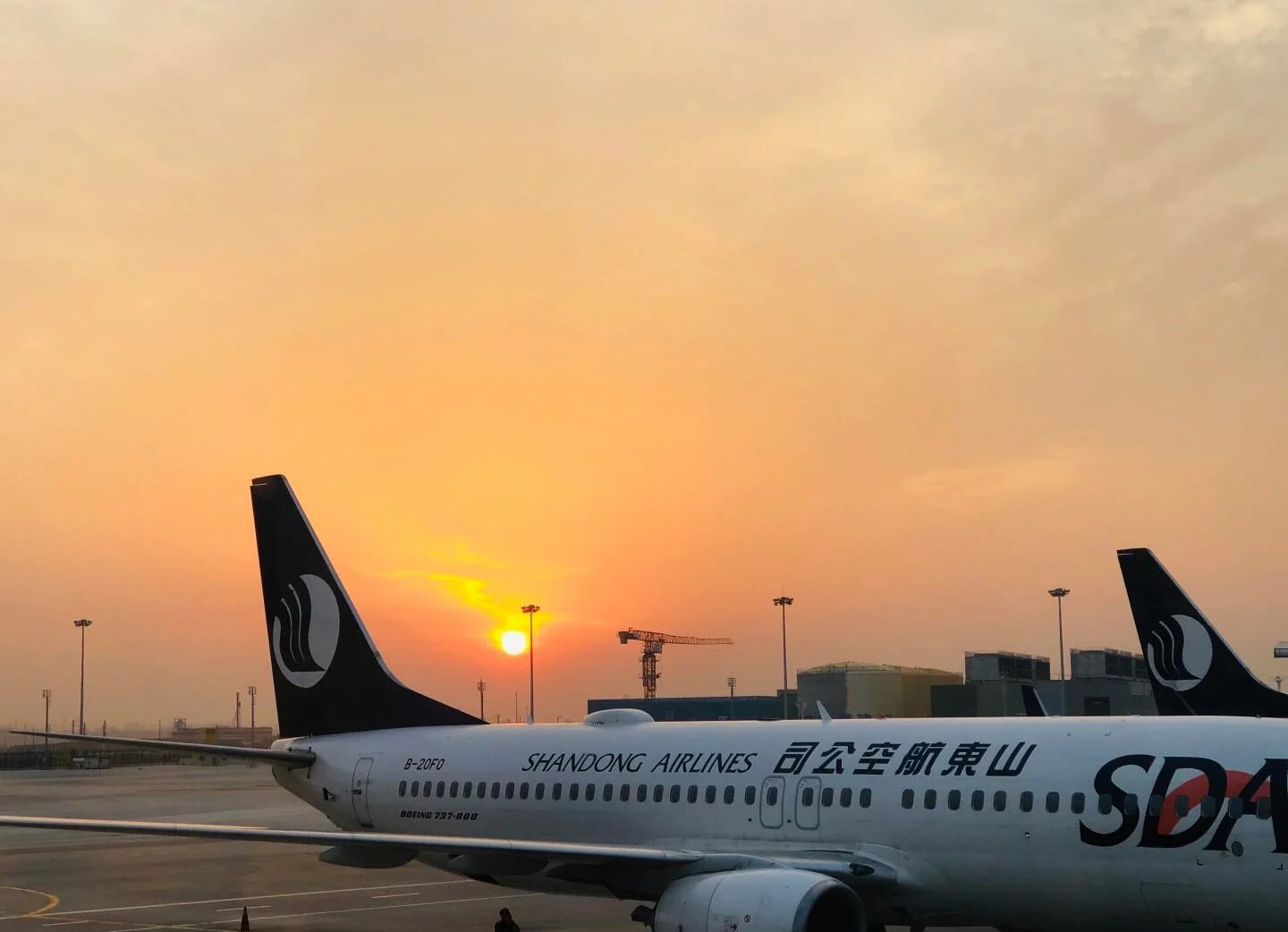 Jinan Yaoqiang International Airport ved solnedgang, Shandong Airlines-fly parkeret på landingsbanen under en varm solnedgangshimmel og rejseatmosfære - Jinan rejseguide: Bedste rejseplan og tips 2026 - The China Journey Jinan Yaoqiang International Airport ved solnedgang, Shandong Airlines-fly parkeret på landingsbanen under en varm solnedgangshimmel og rejseatmosfære - Jinan rejseguide: Bedste rejseplan og tips 2026 - The China Journey