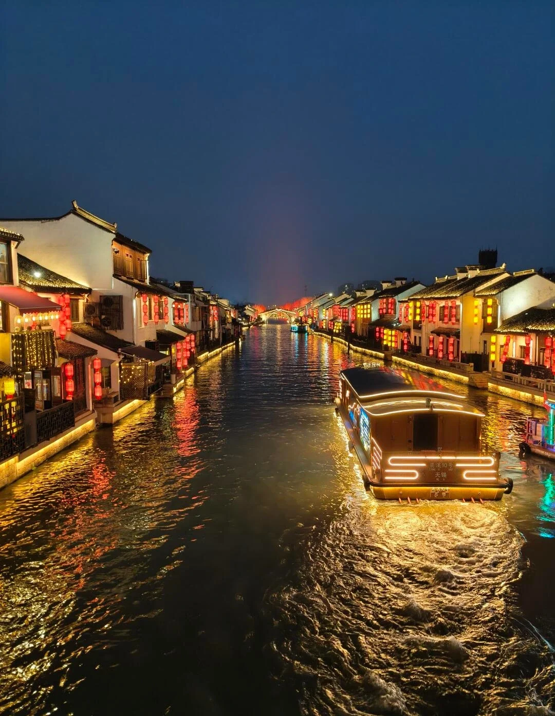 Kanalen ved Nanchang Street om aftenen i Wuxi, båd gennem en oplyst kanal omgivet af historiske bygninger og farverige lanterner - Wuxi rejseguide: Bedste rejseplan og tips 2026 - The China Journey Kanalen ved Nanchang Street om aftenen i Wuxi, båd gennem en oplyst kanal omgivet af historiske bygninger og farverige lanterner - Wuxi rejseguide: Bedste rejseplan og tips 2026 - The China Journey