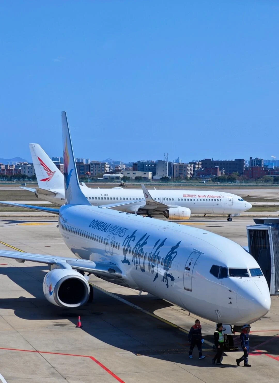 Vliegtuigen op Quanzhou Jinjiang Airport, passagiersvliegtuigen op de startbaan met grondpersoneel en terminal onder blauwe lucht - Reisgids voor Quanzhou: beste route, eten & tips 2026 - The China Journey Vliegtuigen op Quanzhou Jinjiang Airport, passagiersvliegtuigen op de startbaan met grondpersoneel en terminal onder blauwe lucht - Reisgids voor Quanzhou: beste route, eten & tips 2026 - The China Journey