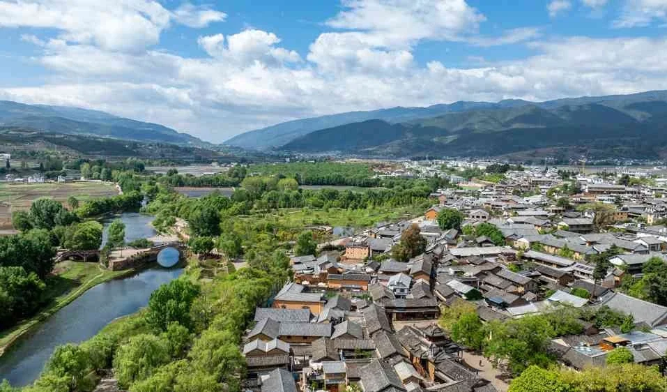 Luchtfoto van de oude stad Shaxi met traditionele dorpsdaken, rivier, velden en bergen op het platteland van Yunnan - Reisgids voor Dali: beste routes en tips 2026 - The China Journey Luchtfoto van de oude stad Shaxi met traditionele dorpsdaken, rivier, velden en bergen op het platteland van Yunnan - Reisgids voor Dali: beste routes en tips 2026 - The China Journey
